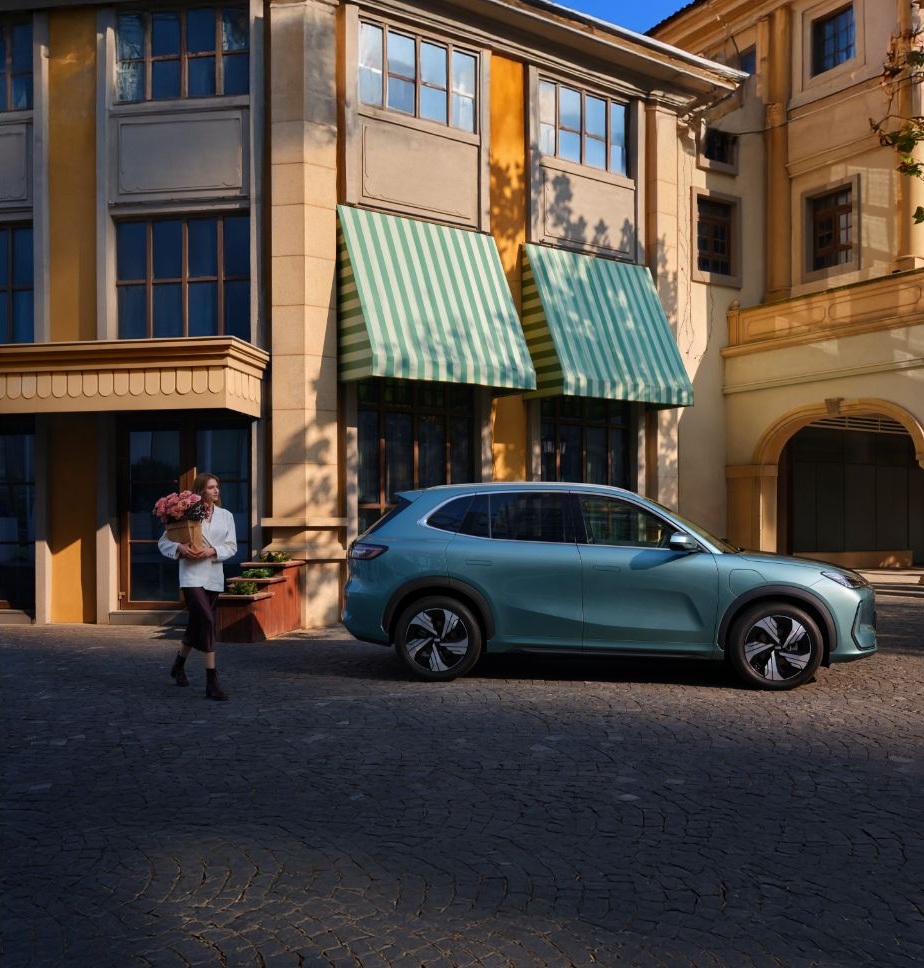 Widok z boku na zaparkowane zielone auto GEELY w środku miasta