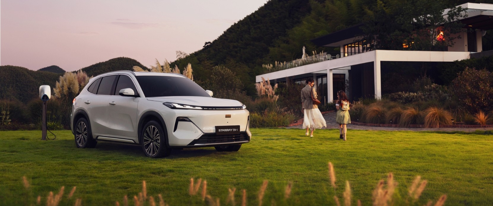 Kobieta z córką i samochodem STARRAY EM-i przed domem