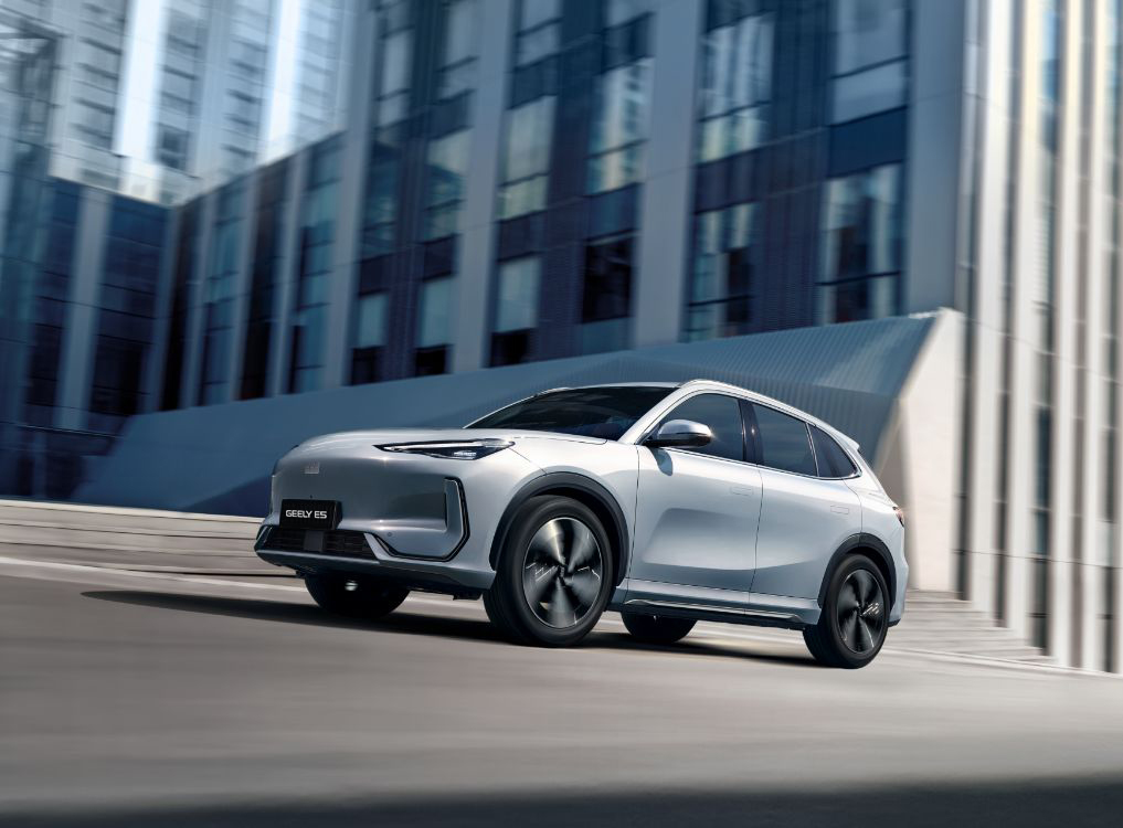 Samochód GEELY E5 podjeżdzający pod strome wzniesienie w mieście